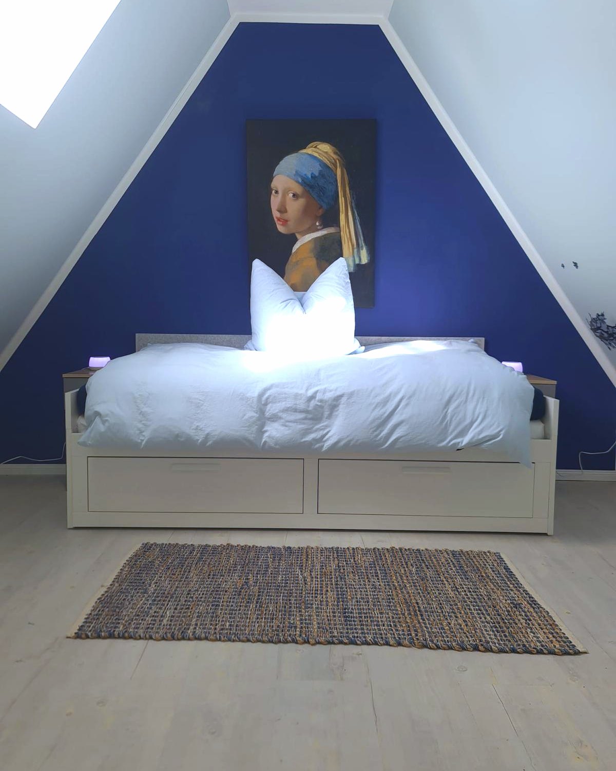 Dachgeschoss mit blauer Giebelwand und Bett